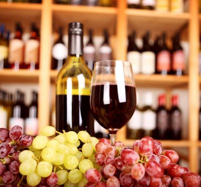 a glass of wine and grapes on a table