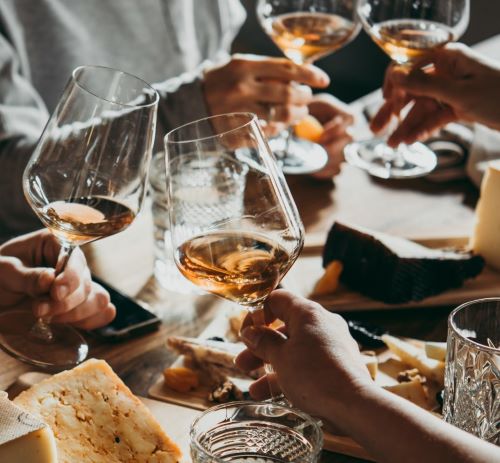people holding wine glasses and wine glasses on a table