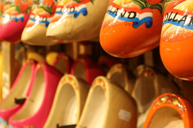Traditional Dutch wooden clogs painted with colorful tulips and windmills in a souvenir shop.