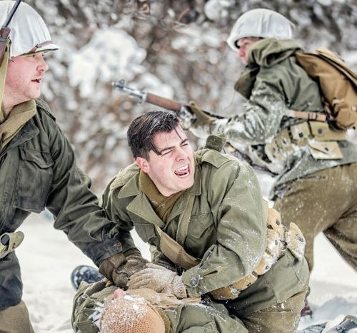 a man in a military uniform is holding a rifle
