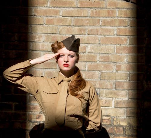 a woman in a military uniform is posing for a photo