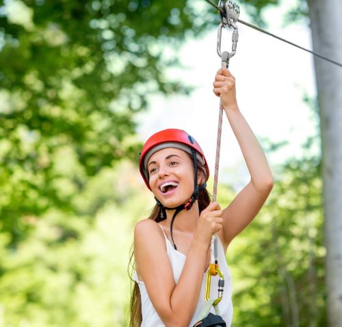 a woman in a helmet and helmet on a zip line