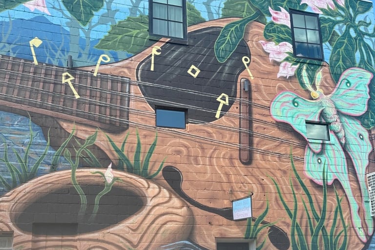 Guitar and luna moth painting on a building representing locksmith for Mars Hill, NC