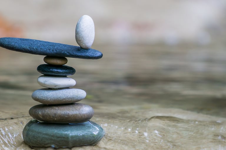 A pile of stones on sand, with one stone on the top balancing