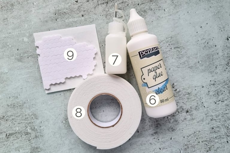Set of card making adhesives and glue on a glass surface