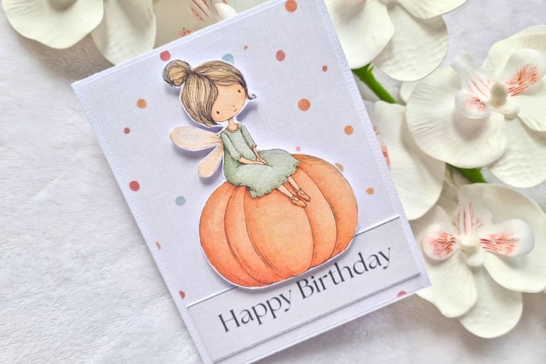 Cute handmade greeting card with adorable cute little fall fairy sitting on a pumpkin.