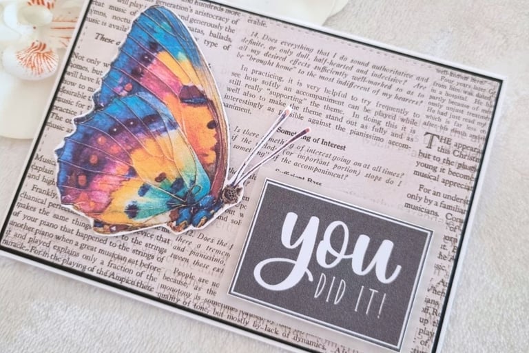 Handmade greeting card with a butterfly, newspaper background and "You Did It" printable sentiment.