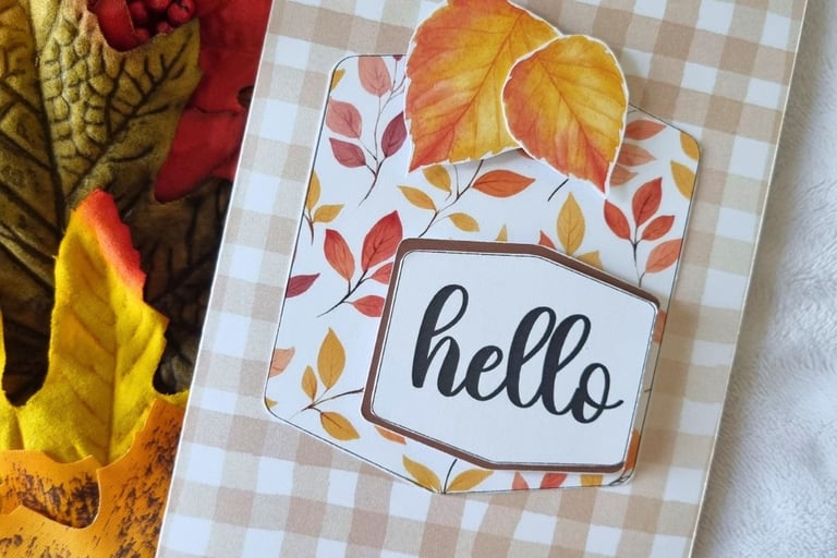 Fall greeting card with "hello" text, featuring autumn leaves in red, yellow, and orange