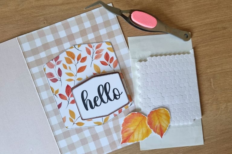 Crafted fall card on checkered background with "hello" text