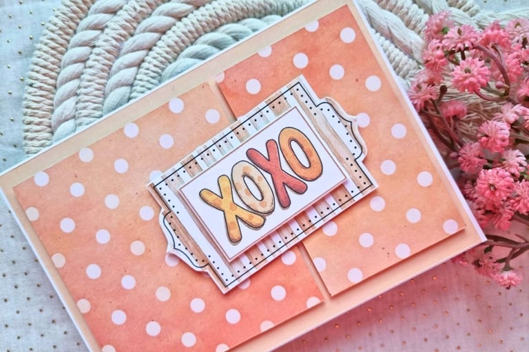 Handmade greeting card with orange background and white dots. Sentiment "XOXO" is in the center.