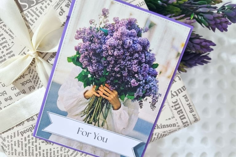 A magazine page of a person in a white dress holding a large bouquet of purple flowers.