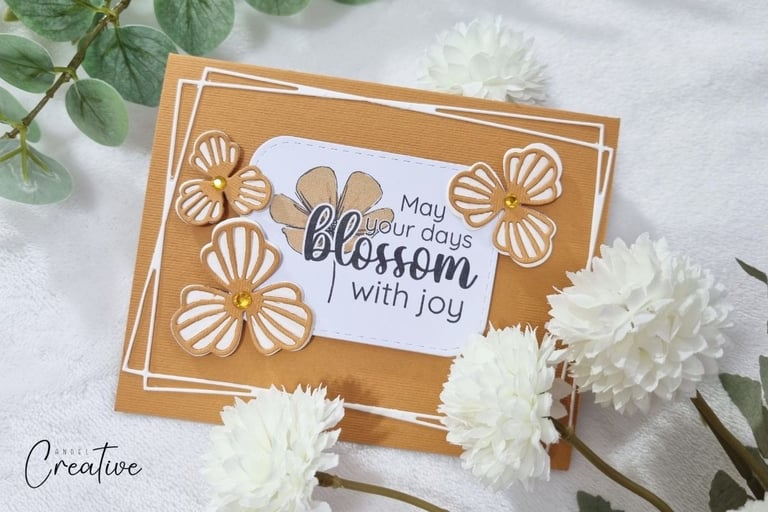 Orange handmade spring card with die cut flowers and spring-themed sentiment