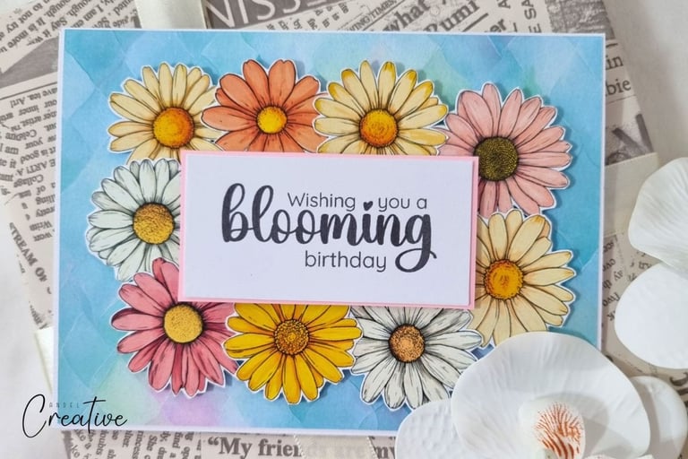 Handmade greeting card with lot of yellow, white and blush flowers on the blue background.