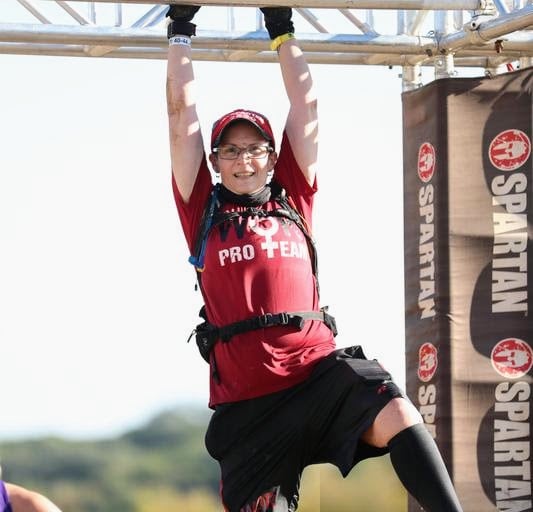 Elizabeth from WOR on monkey bars at Spartan Race