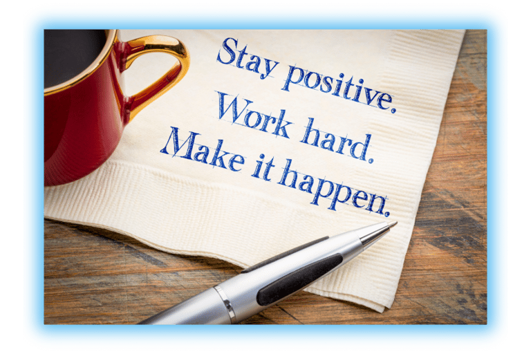 Napkin with the words, "Stay positive. Work Hard. Make it happen"  on table with a cup of coffee and a pen