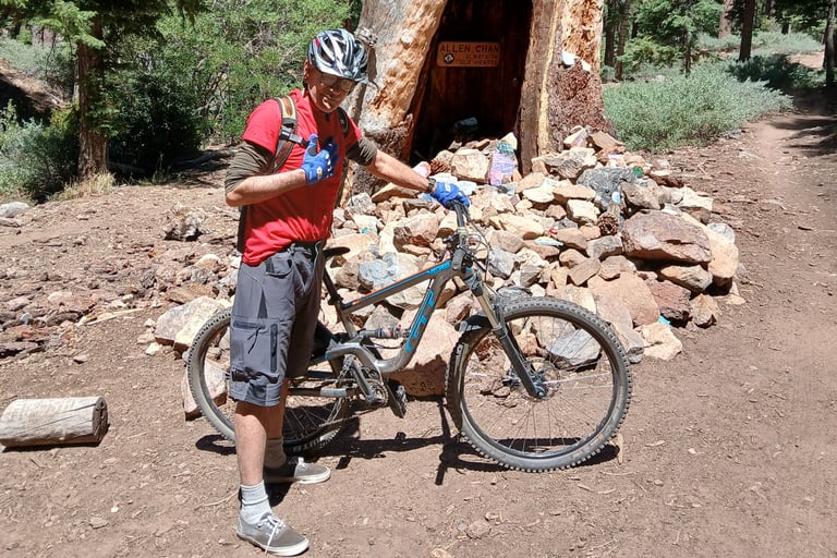Mountain biker standing next to bike giving thumbs up sign wearing mtb gloves