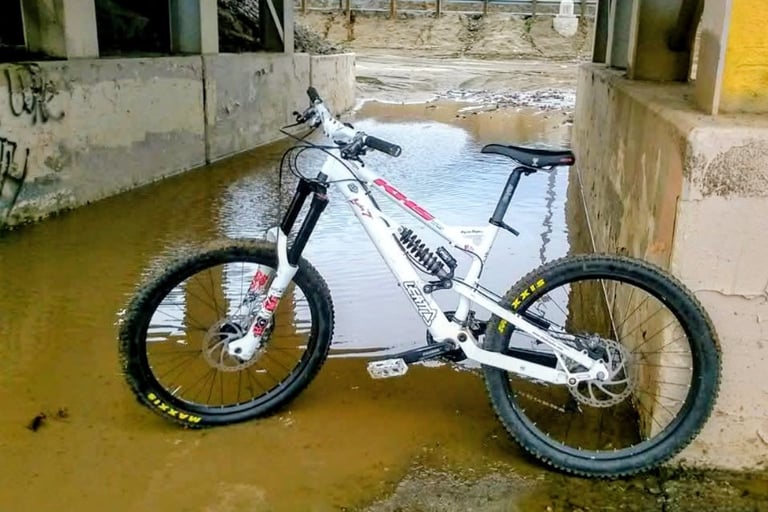 Mountain bike with Maxxis tires parked in flooded wash after winter storm in Southern California
