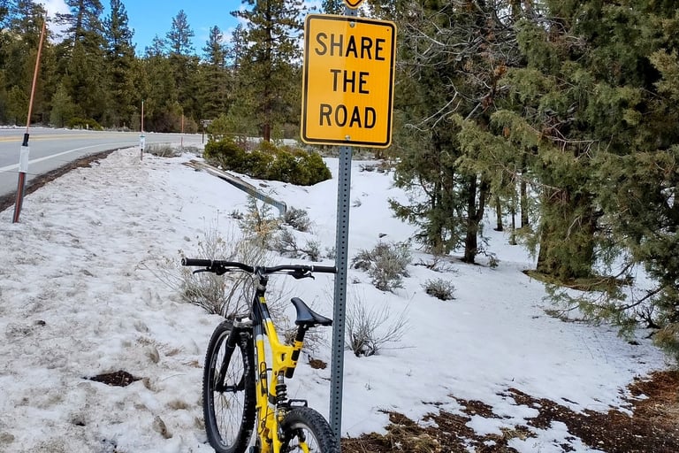 Mountain bike leaning against share the road sign in snowy Big Bear California