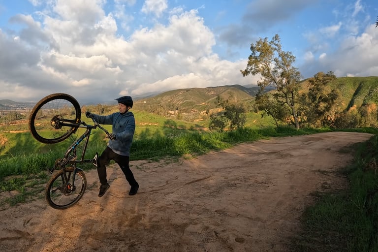 mountain biker safely bailing out of a wheelie