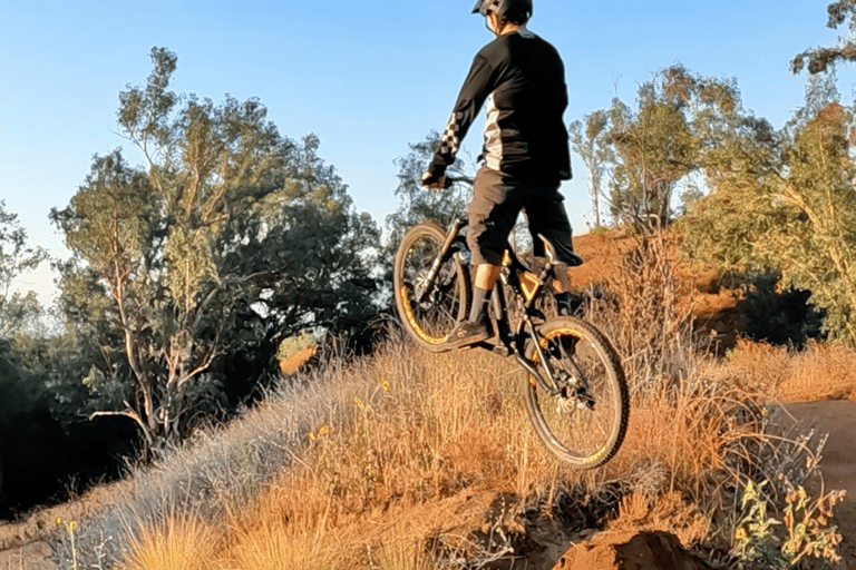 Rider frozen and stiff over a jump, bike flat in the air — showing dead sailor posture