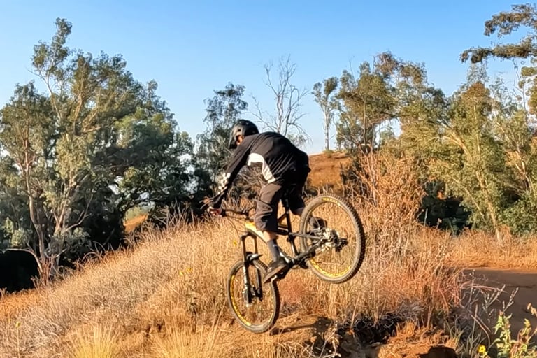 Mountain biker pitched forward and nose heavy on a jump landing, risk of front wheel dive