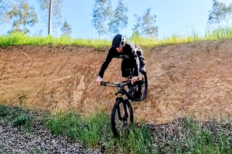 mountain biker halfway down a steep drop in