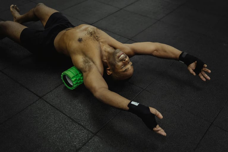 Man lying on a foam roller performing back and muscle release exercises to improve mobility and reco