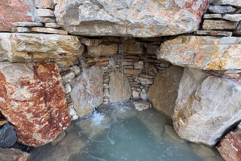 Handcrafted grotto cave under waterfall with limestone & quartzite for natural pool | Aqua Vitae