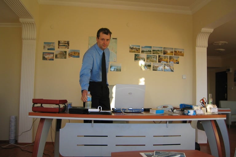 Jörg Grube steht hinter seinem ersten eigenen Schreibtisch