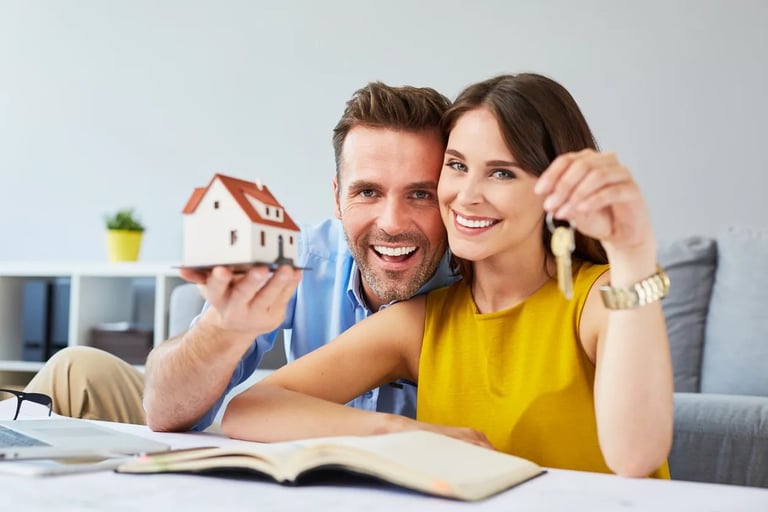 a man and woman holding keys to a house