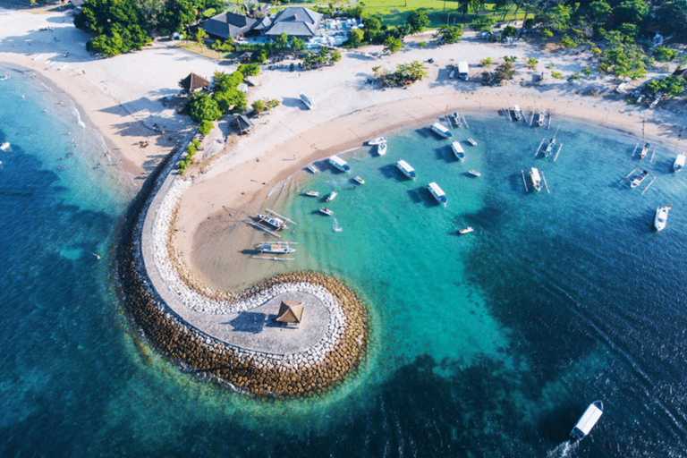 a beach with boats and blue water