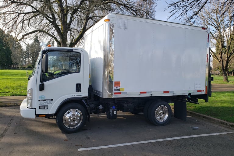 a white truck with a white boxy truck in the background