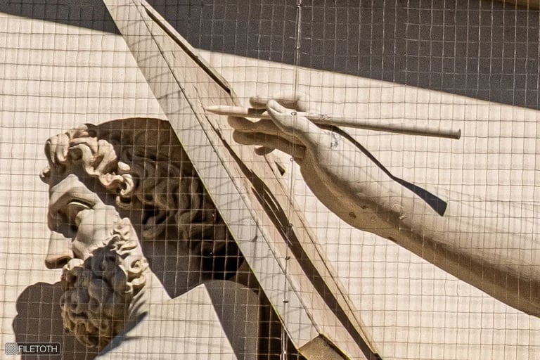 Close-up of the writing hand of the female statue representing History on the museum’s pediment.