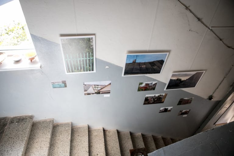 Paintings in the corridor above the stairs. Photos are hung and stuck as stickers. 