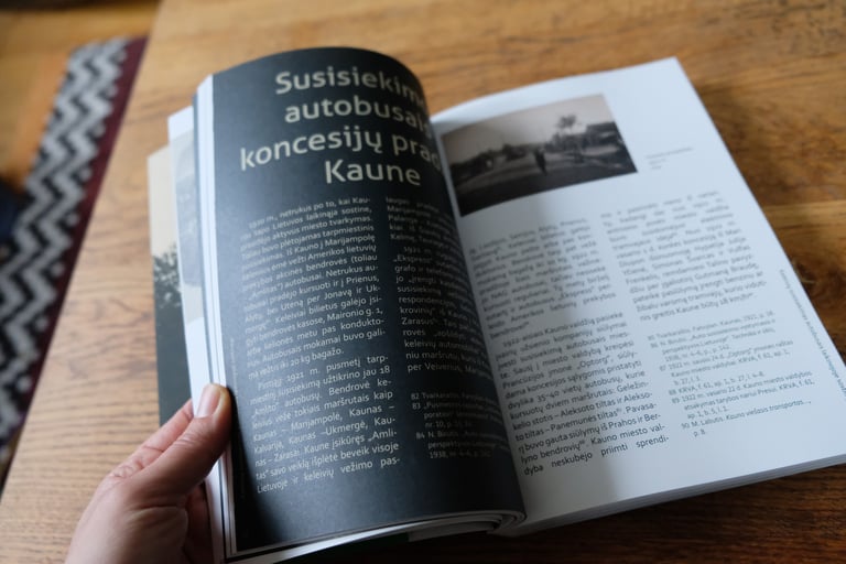 The photo shows the pages of a book being turned. The vintage photograph and the textual information are visible. 
