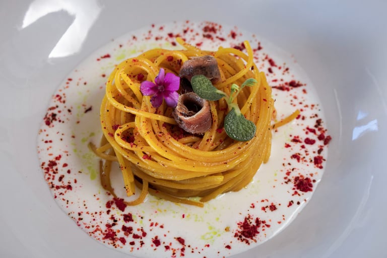 spaghetti allo zafferano su fonduta di formaggio e alici