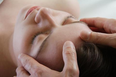 een vrouw krijgt een manuele behandeling aan haar hoofd