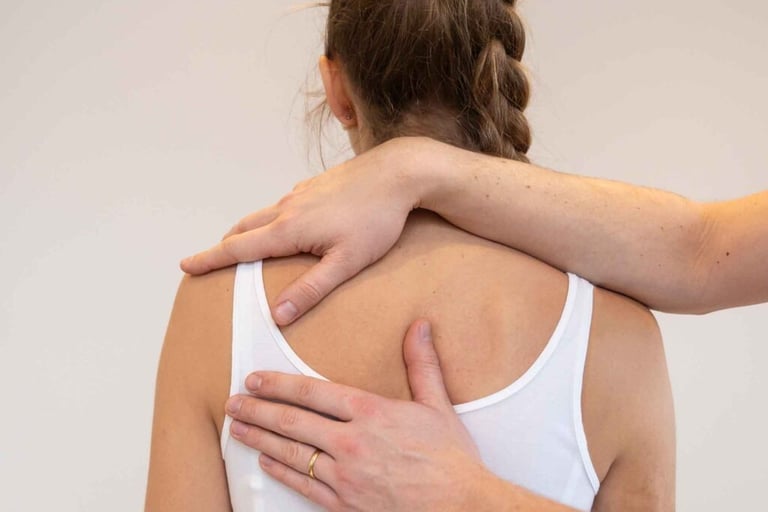 een vrouw met een witte tank top met 2 handen op haar rug.