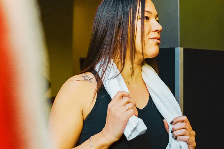 Cooling towel draped around woman's neck at a gym