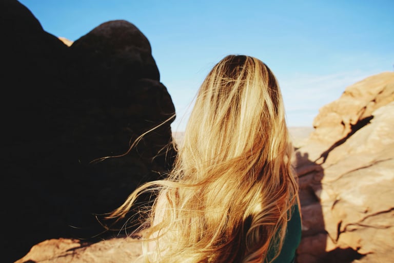 lady with blonde hair looking out over the mountains
