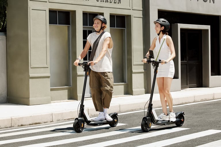 two people standing on a street with scooters