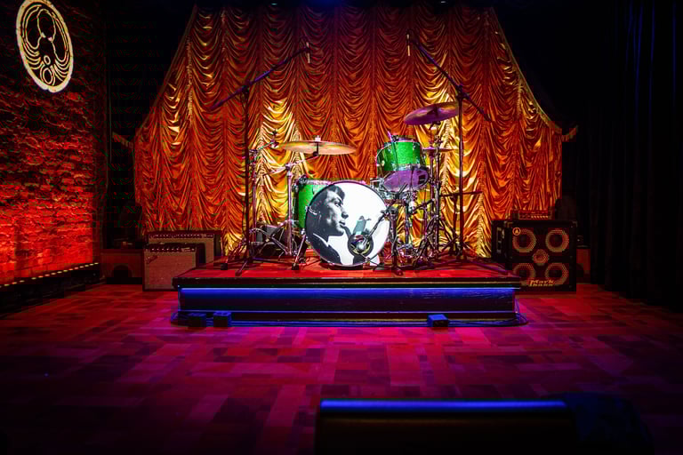 The Eighth Room stage in Nashville featuring warm lighting, gold drapery, and a Martin Audio sound s