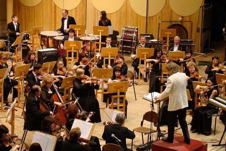 une chef d'orchestre dirige ses musiciens