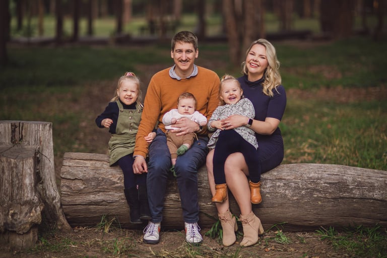 a family of five sitting on a log log