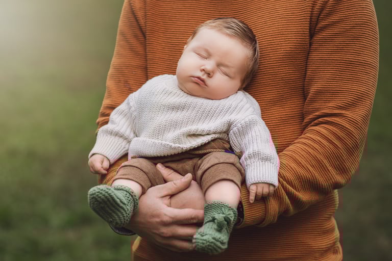a baby boy sleeping on his father's lapel