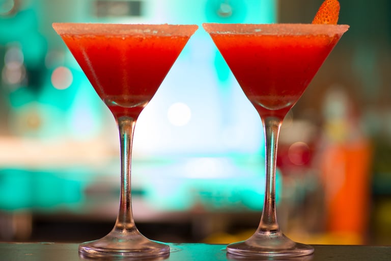 Dos cócteles de daiquiri de fresa roja en copas de martini con bordeado con sal.