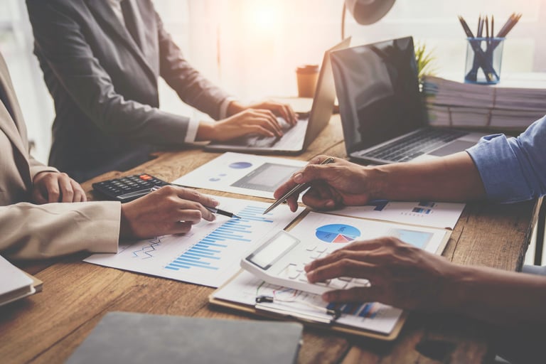 a group of people sitting at a table with papers and calculator