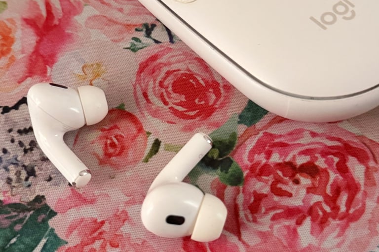 airpods next to a computer mouse on a rose print mousepad