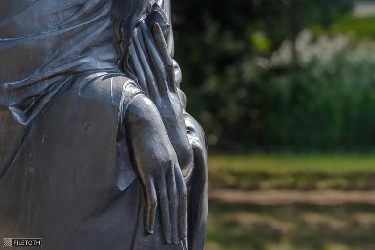 Close-up of meditative hands in lap, fingers loosely touching in tranquil awareness.