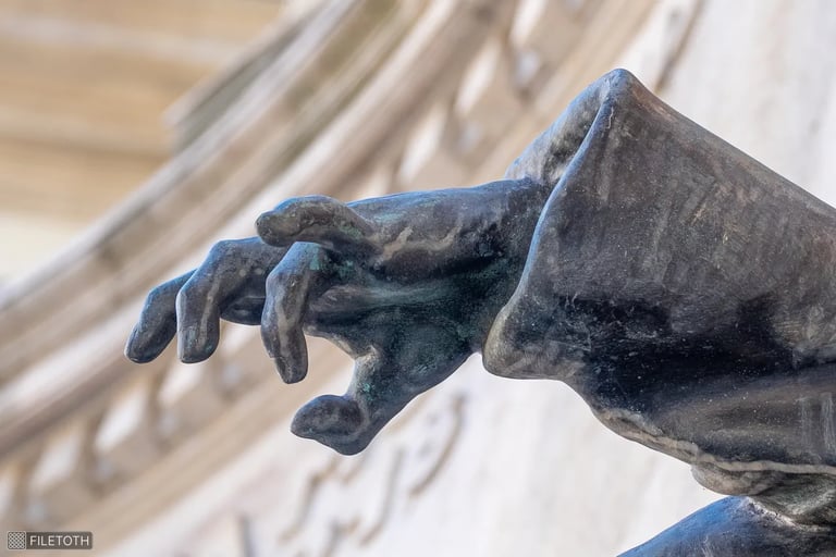 Wounded soldier’s bronze hand from the ELTE heroic memorial, fingers slack.